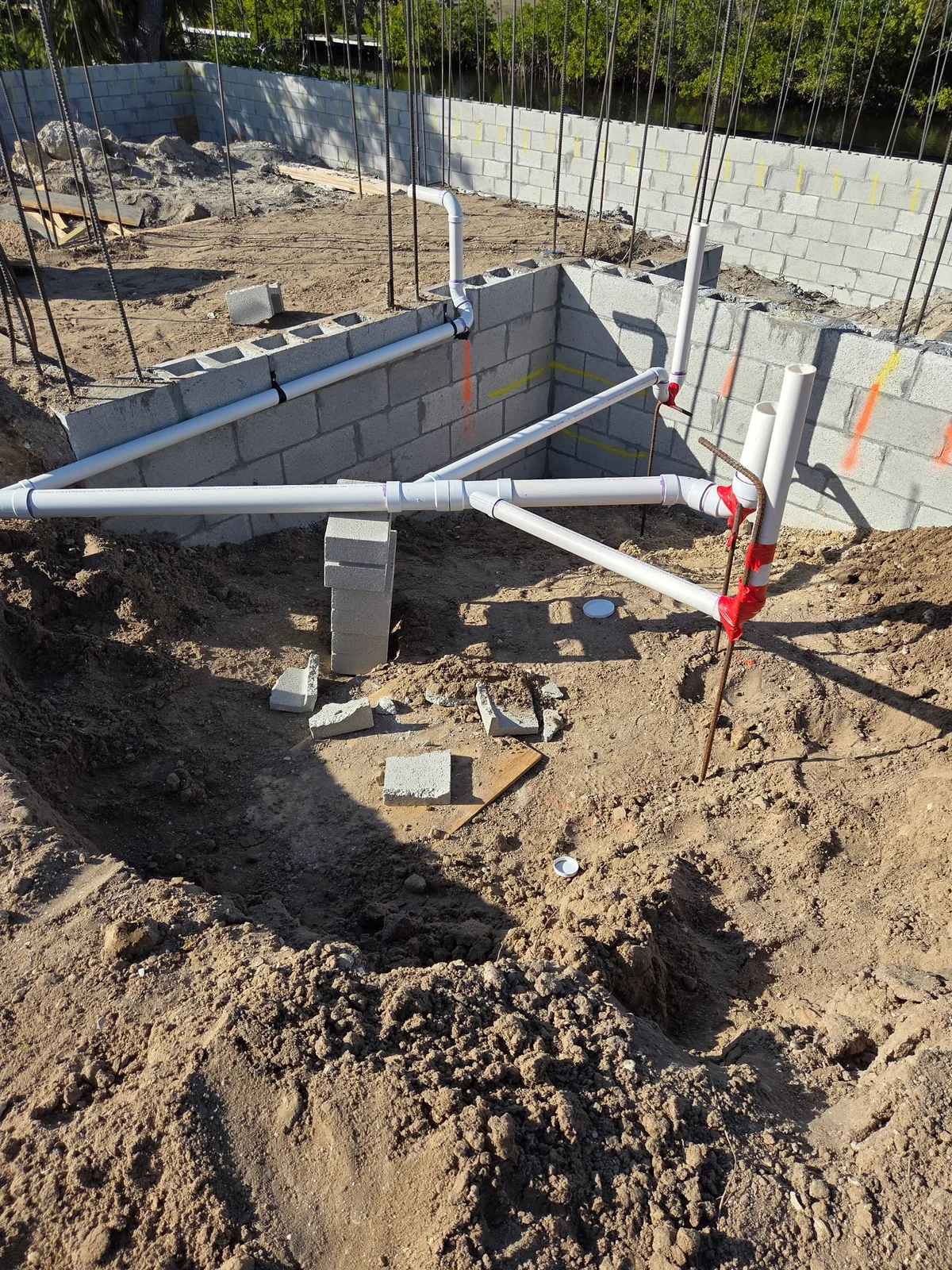 Under-slab plumbing rough-in inside a new concrete block wall foundation